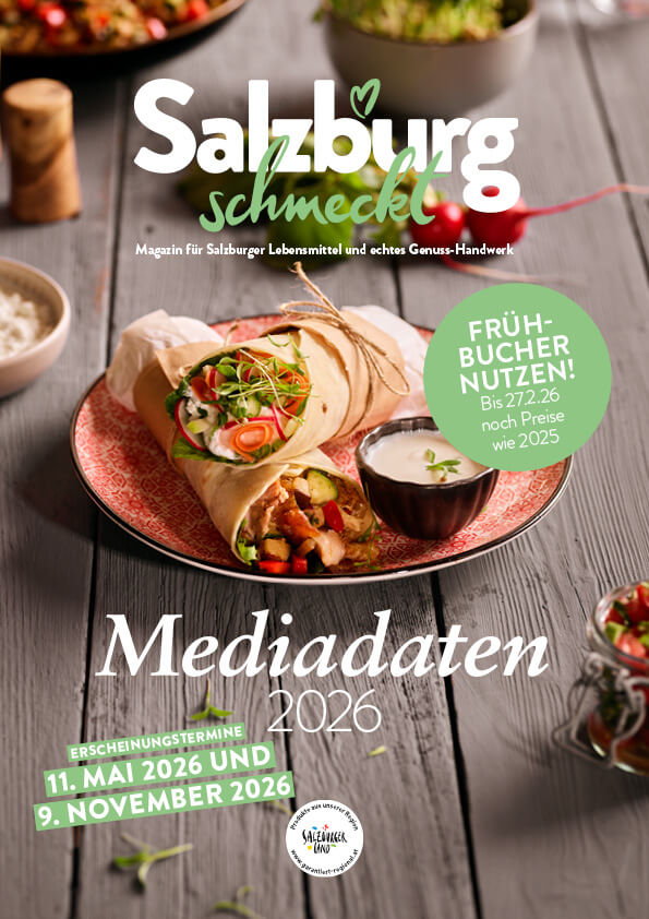 Das Bild zeigt ein Magazin-Cover mit dem Titel "Salzburg schmeckt" und dem Untertitel "Mediadaten 2026". Es präsentiert ein appetitliches Gericht mit Tortilla-Wraps, Gemüse und Dip auf einem Holztisch. Der Hintergrund ist rustikal und einladend.