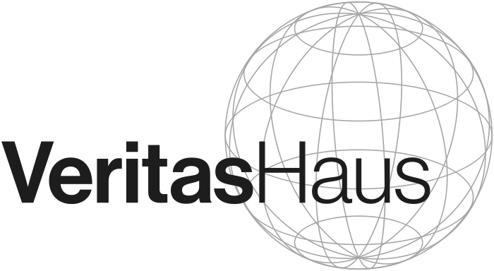 Das Bild zeigt das Logo von VeritasHaus, das aus einem stilisierten Haus-Symbol und dem Schriftzug "VeritasHaus" besteht. Das Haus-Symbol ist in einem Kreis mit Linienmuster dargestellt.